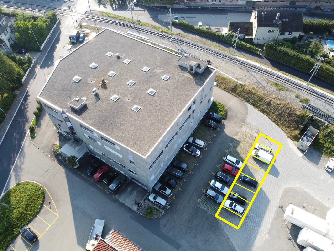 Luftaufnahme des Gebäudes mit gelb markierten Parkplätzen
